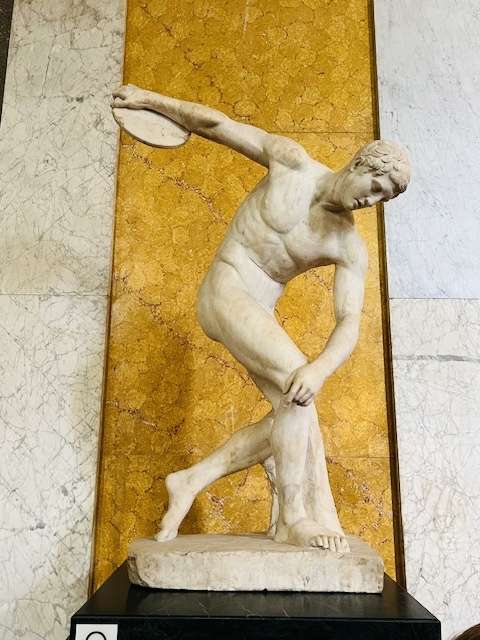 Sculpture of naked discus thrower on a pedistal in London museum